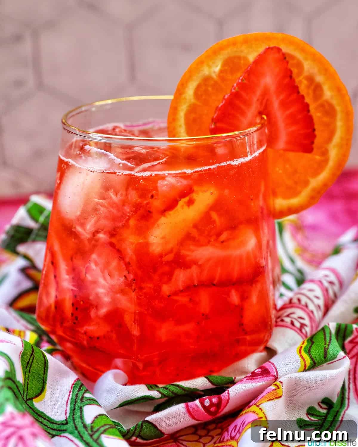Delicious Strawberry Spritz with fresh orange and strawberry garnish.