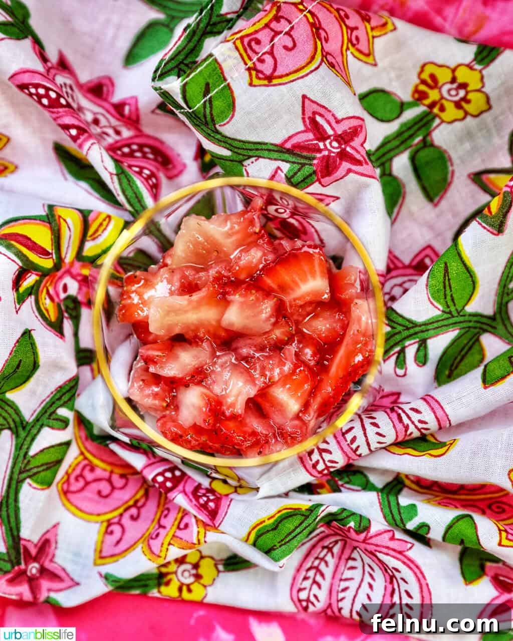 A glass with muddled strawberries at the bottom.