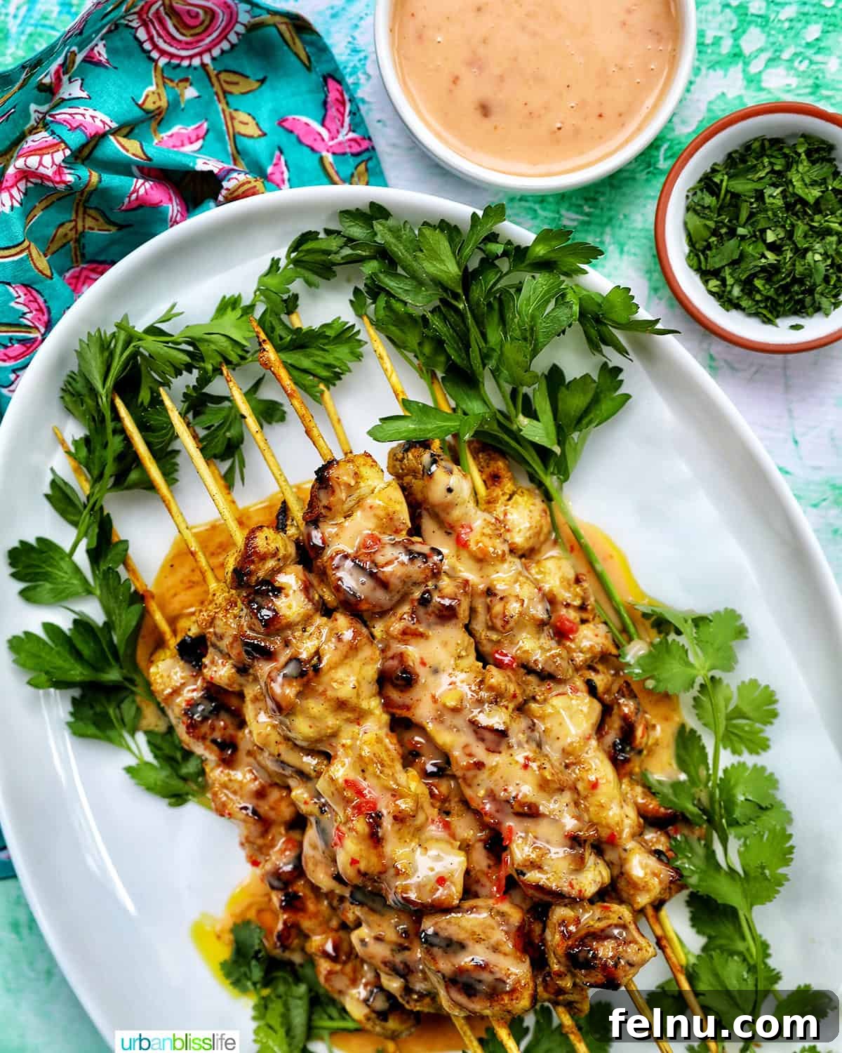 Spicy Peanut Glazed Chicken Skewers 15 A stunning platter of Bang Bang Chicken Skewers, garnished with fresh herbs and accompanied by small bowls of extra sauce and lime wedges.