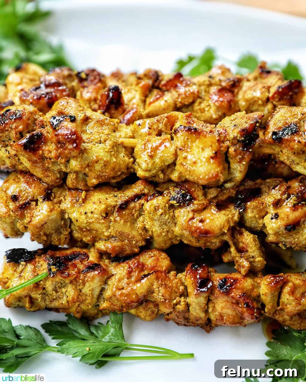 Spicy Peanut Glazed Chicken Skewers 10 A stack of perfectly grilled chicken skewers resting on a plate after cooking.
