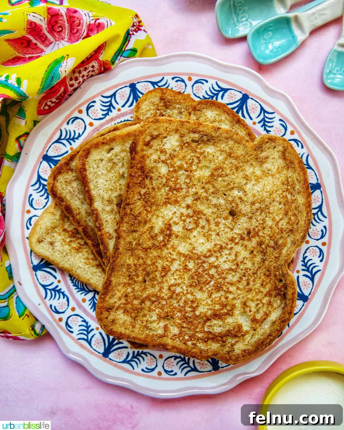 Power-Packed Protein French Toast 2 stack of high protein french toast on a colorful plate, drizzled with syrup and topped with berries.