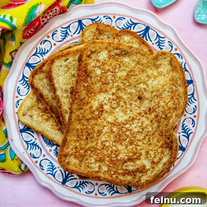 Power-Packed Protein French Toast 11 stack of high protein french toast on a colorful plate, garnished with fruit.