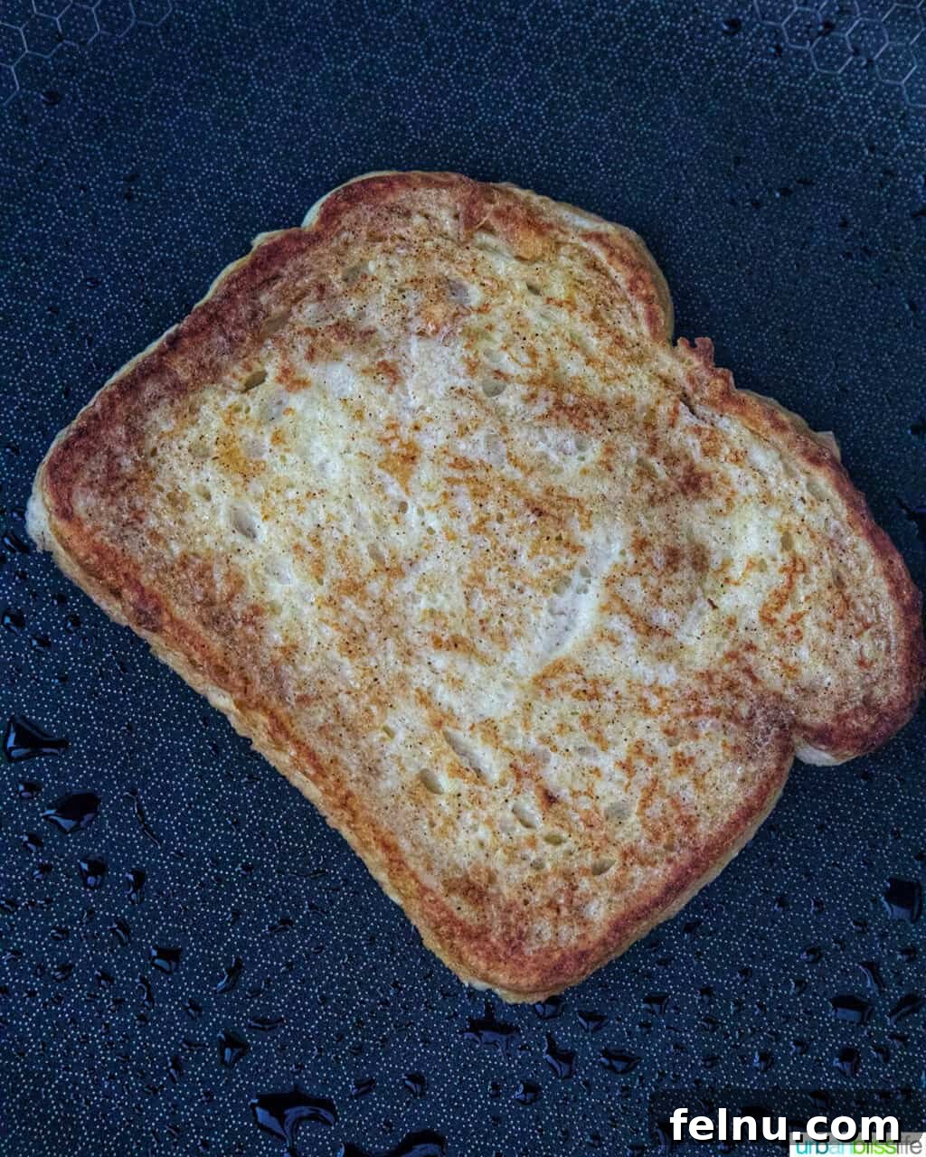Power-Packed Protein French Toast 8 several slices of high protein french toast cooking on a griddle.
