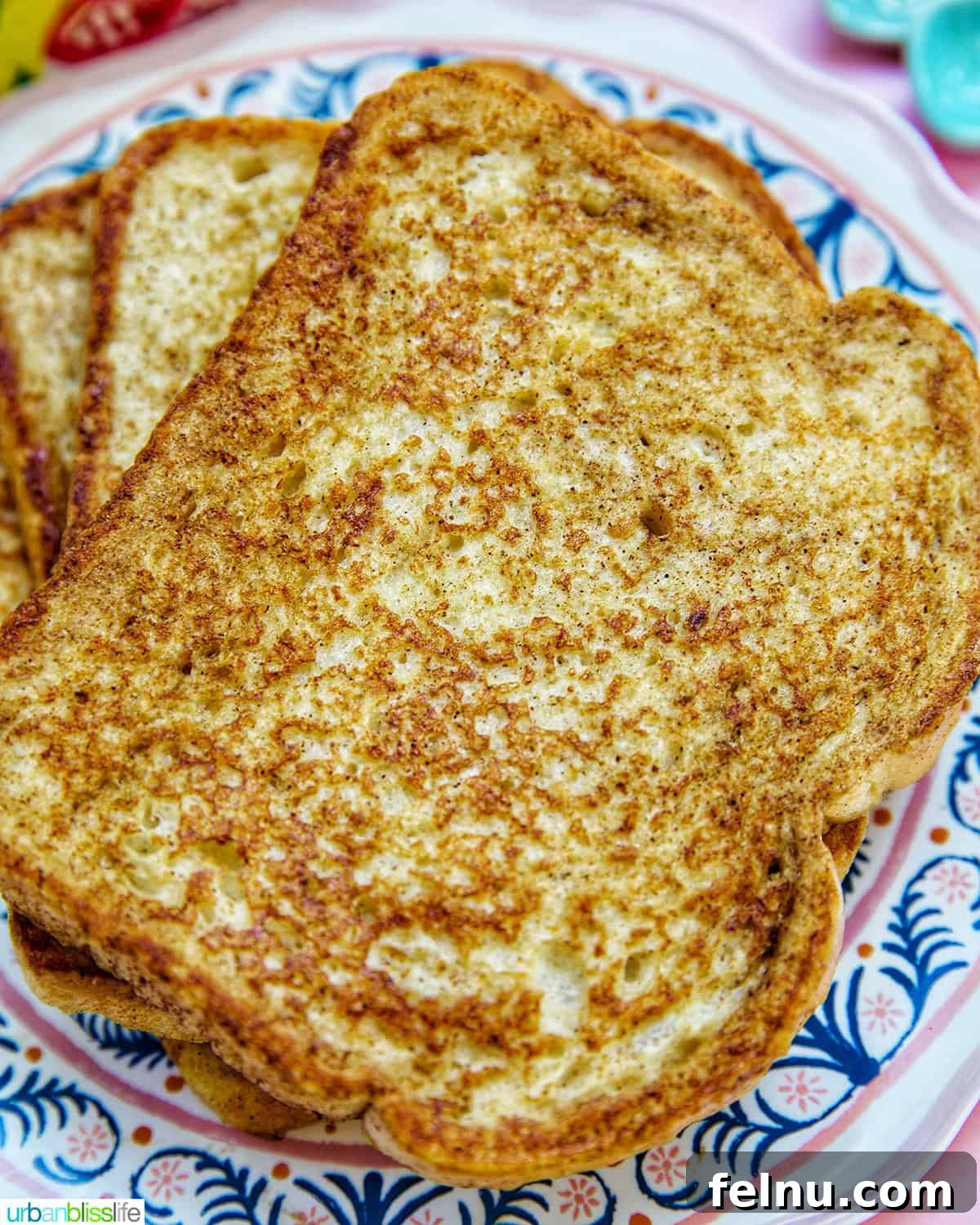 Power-Packed Protein French Toast 9 a close-up stack of high protein french toast on a colorful plate, showing its fluffy texture.