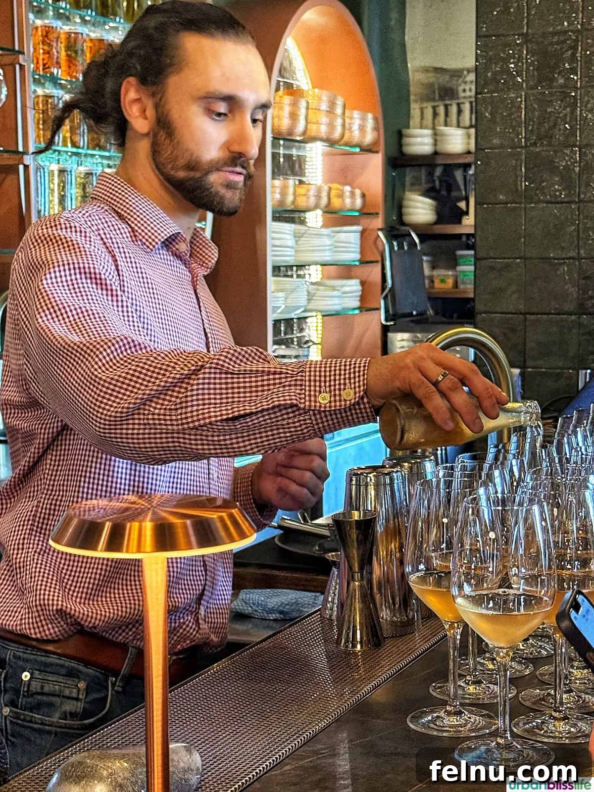 A Taste of Quebec: Culinary Hotspots in the City 17 A skilled bartender expertly pouring drinks into elegant wine glasses at Vieux Carré.