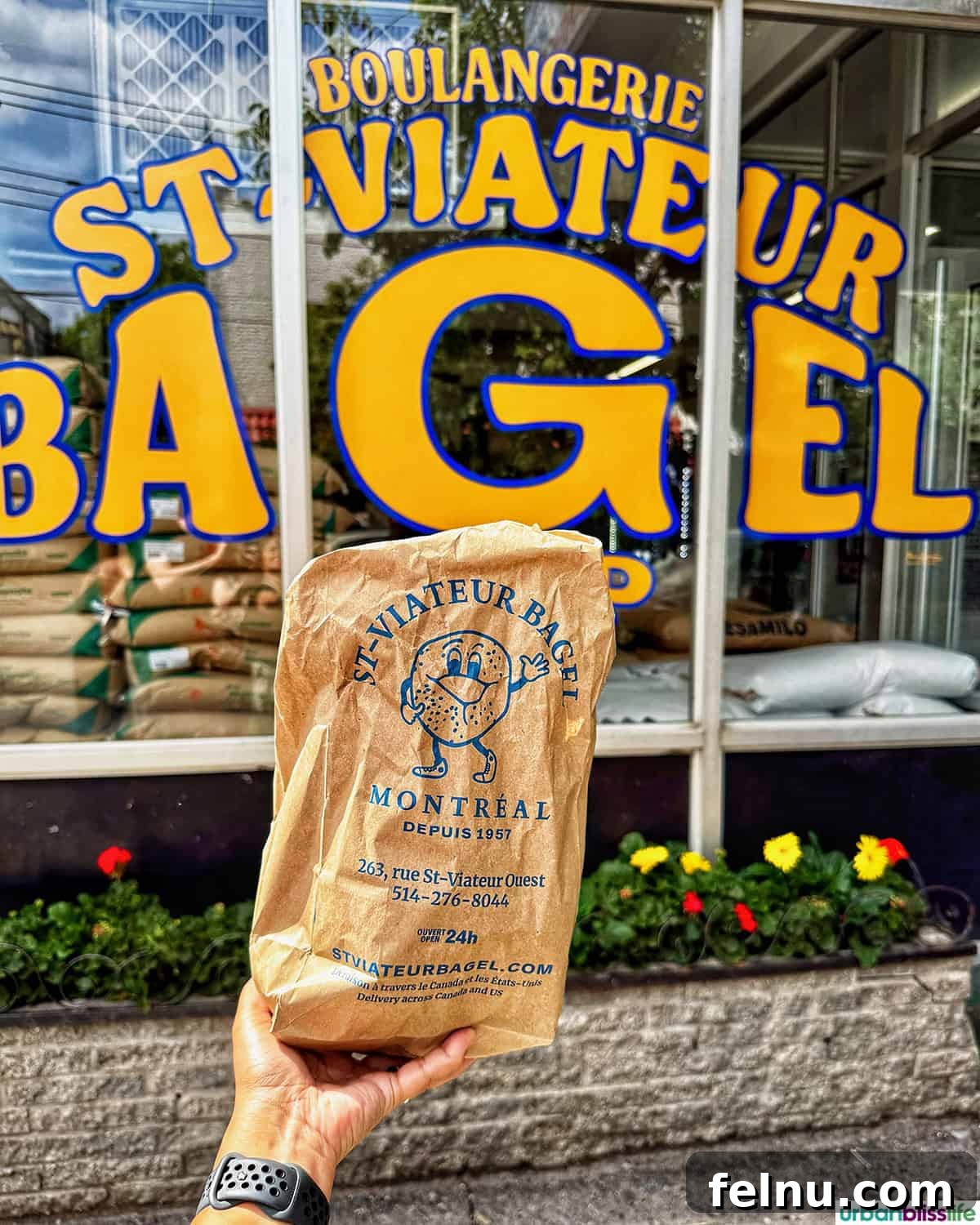 Montreal's Culinary Hotspots 6 An exterior shot of St Viateur Bagels, with a hand holding a bag filled with warm, fresh bagels.