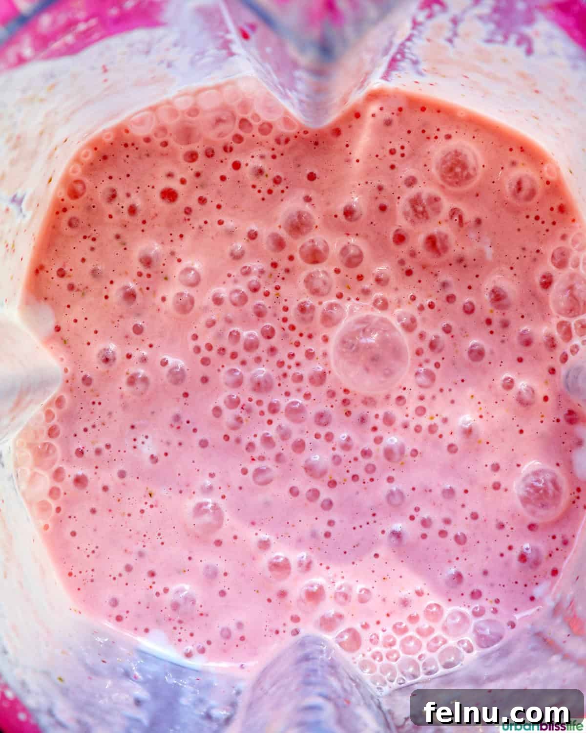 Peachy Berry Bliss 8 The blended strawberry peach smoothie, smooth and perfectly mixed, still in the blender pitcher, ready to be poured.