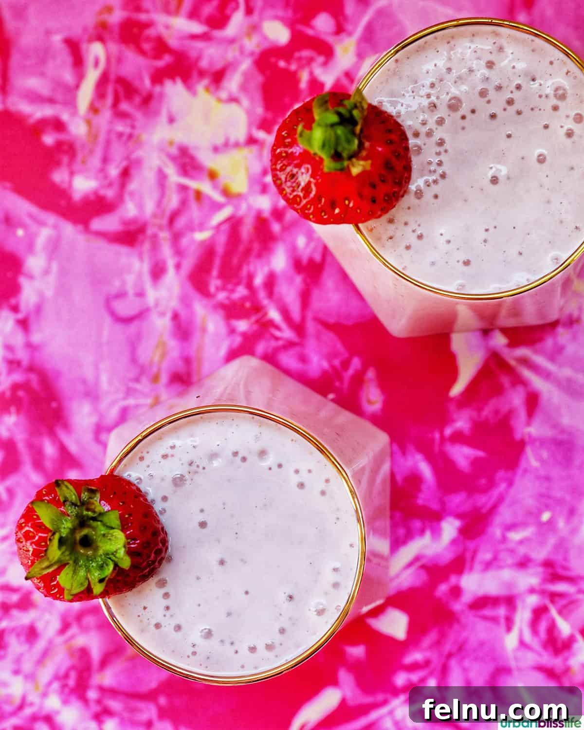 Peachy Berry Bliss 10 Two glasses of strawberry peach smoothies seen from a top-down perspective, highlighting their fresh appearance and inviting appeal.