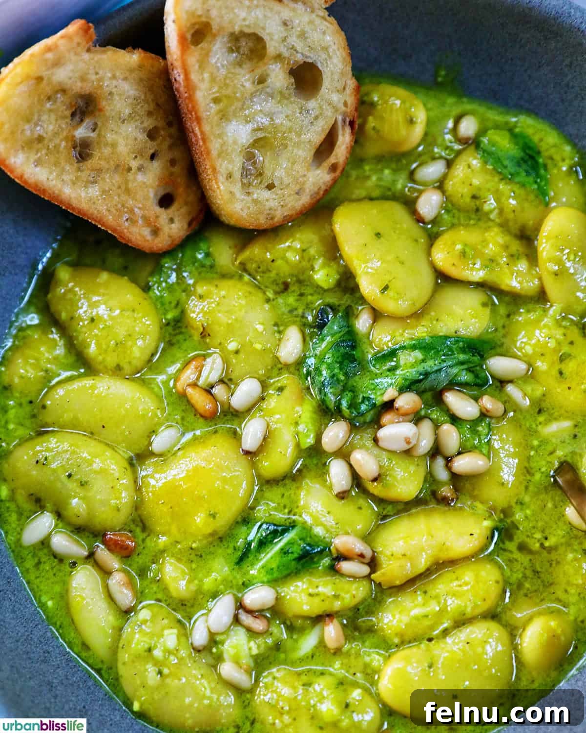 bowl of pesto beans with crostini slices.