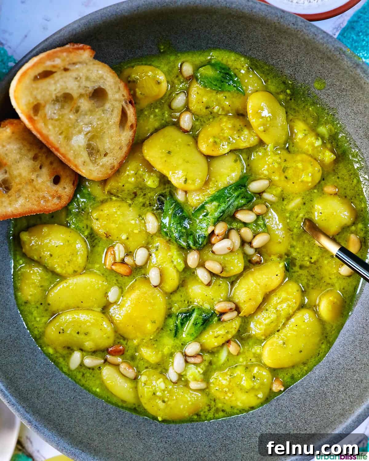 bowl of pesto beans with crostini slices.