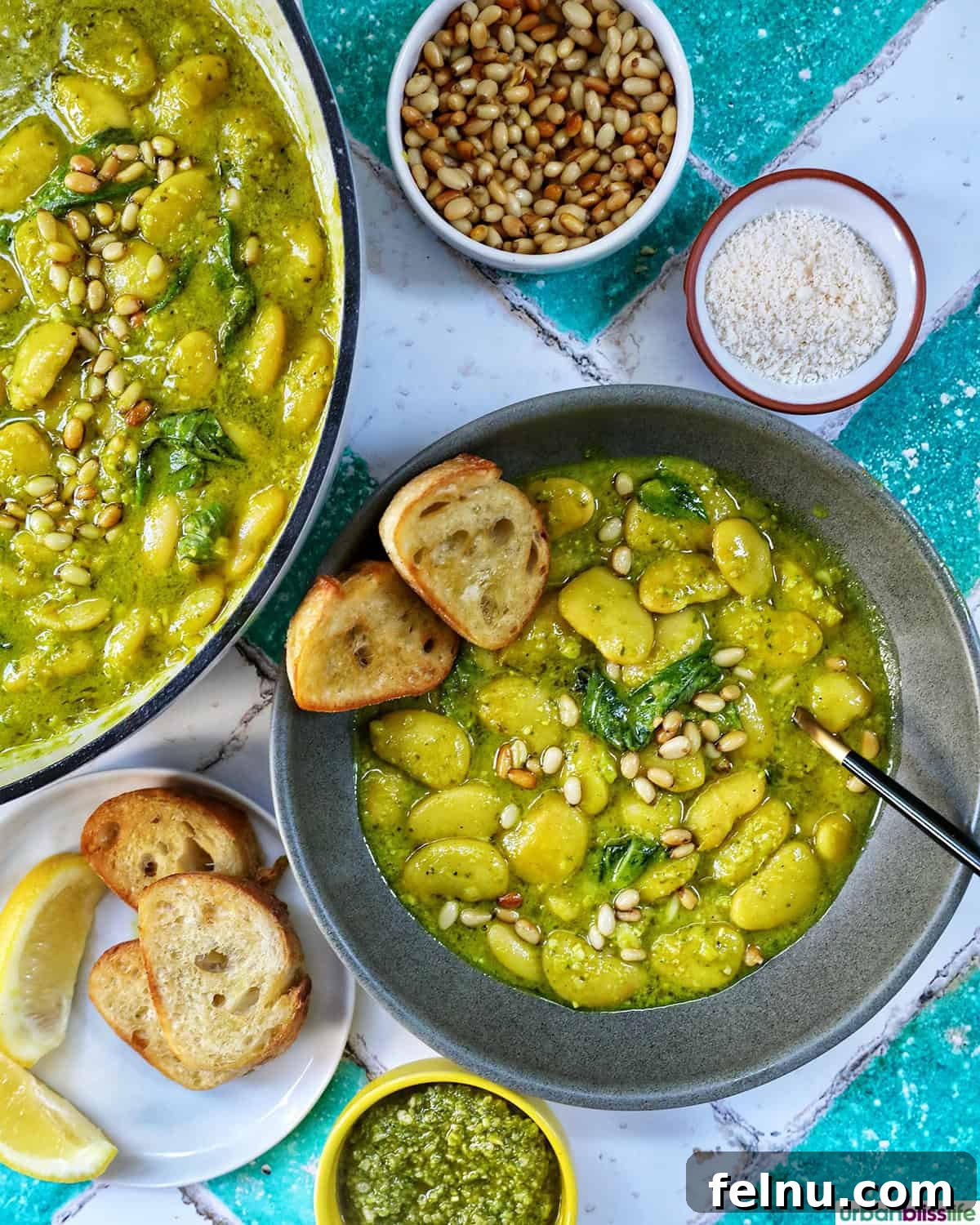 bowl of pesto beans with crostini slices and side bowls of parmesan cheese and pine nuts.