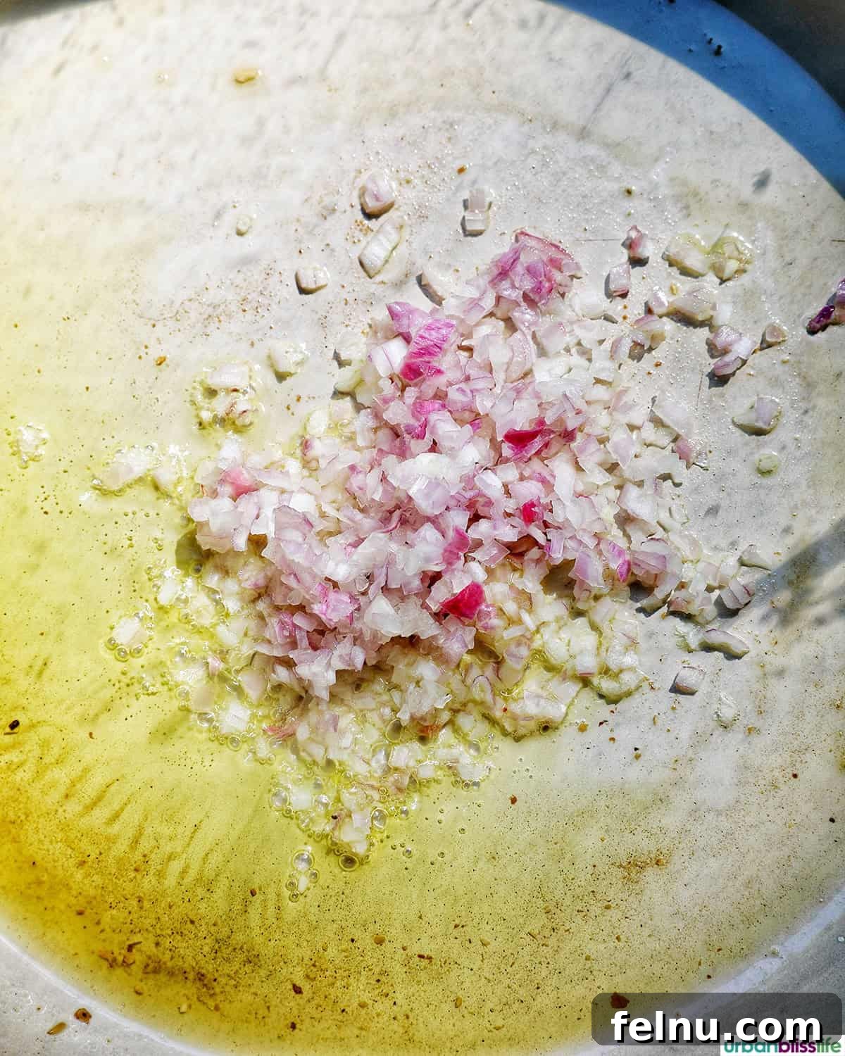 shallots and garlic sauteing in a large pan.