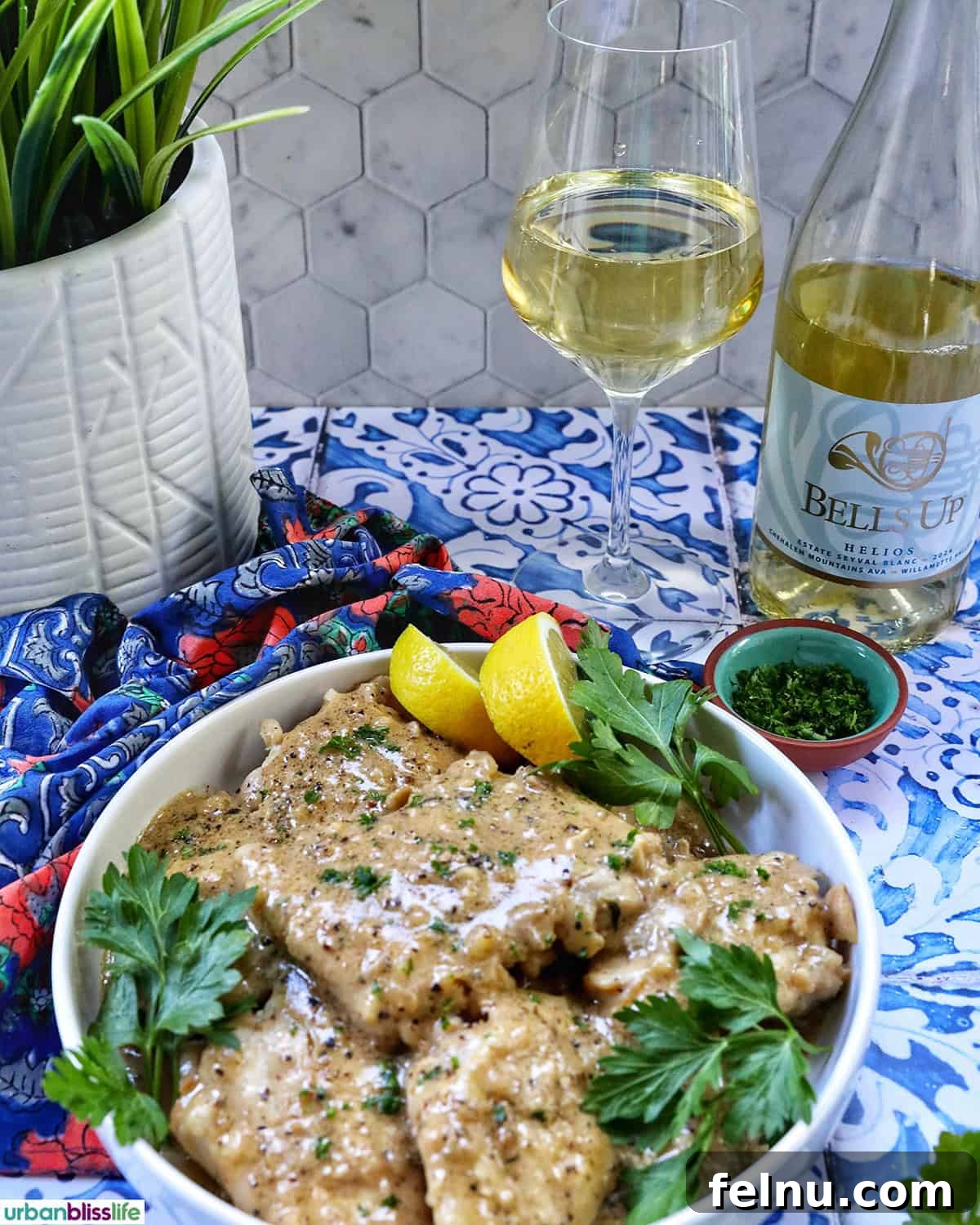 Rich Brandy Peppercorn Chicken 17 Chicken au Poivre served in a bowl with a glass of white wine and a bottle in the background, suggesting a perfect meal pairing.