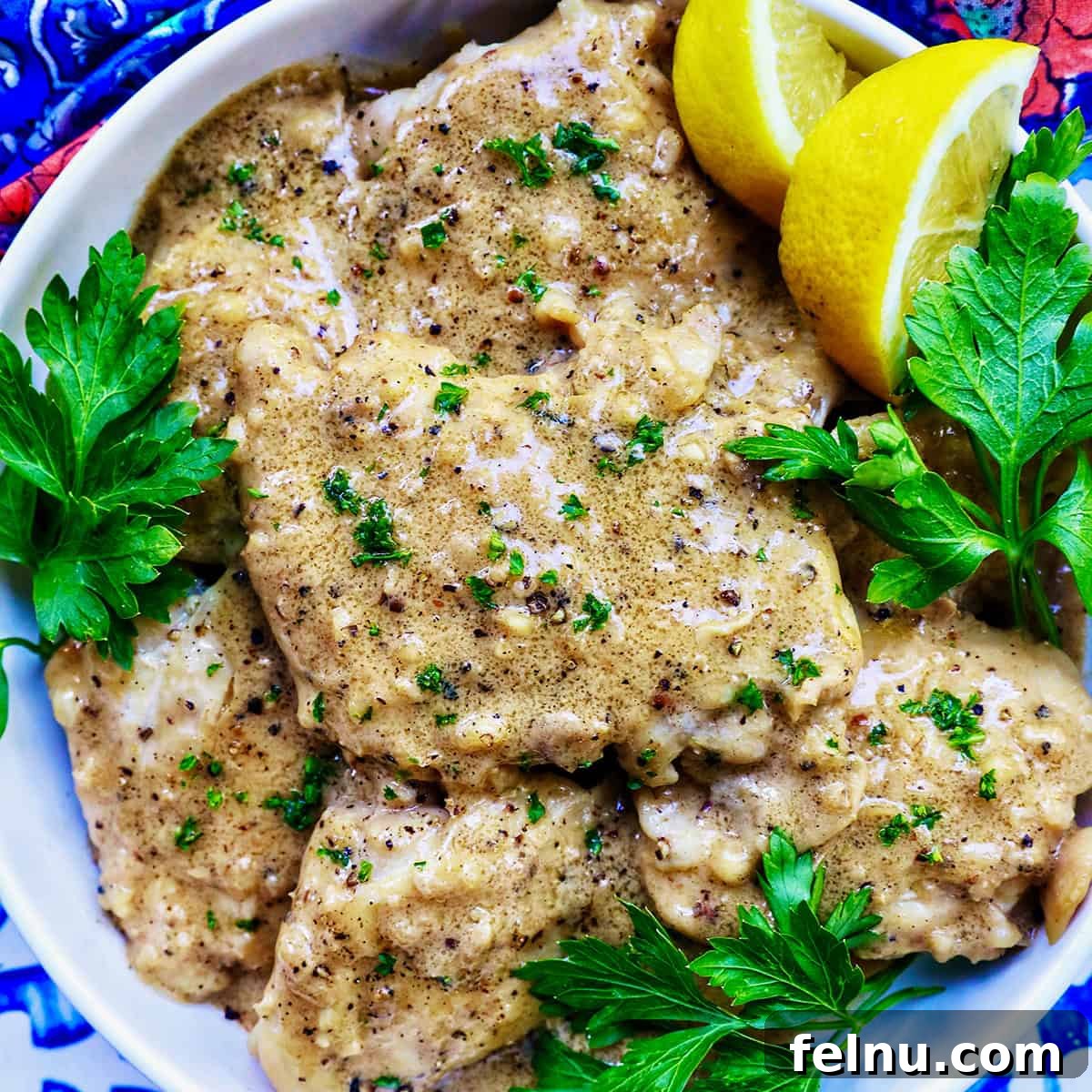Chicken au Poivre, garnished with fresh herbs and lemon slices.