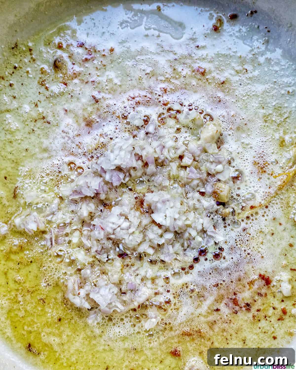Rich Brandy Peppercorn Chicken 10 Finely minced shallots and garlic sizzling and becoming translucent in butter within the pan.
