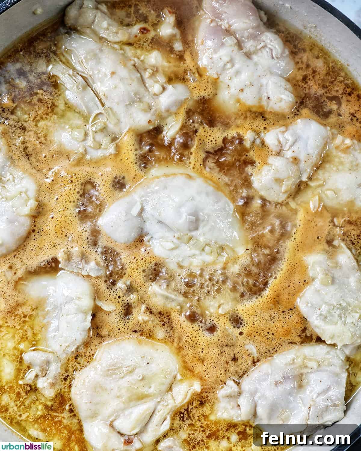 Rich Filipino Peanut Chicken 12 Close-up of chicken cooking in a flavorful sauce, showing its tender texture.