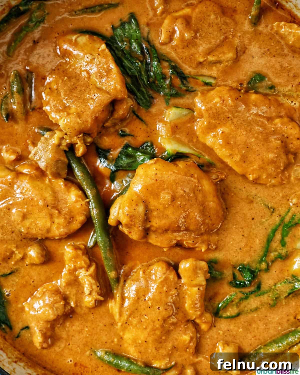 Rich Filipino Peanut Chicken 3 Filipino chicken kare kare simmering in a large pan, viewed from above.
