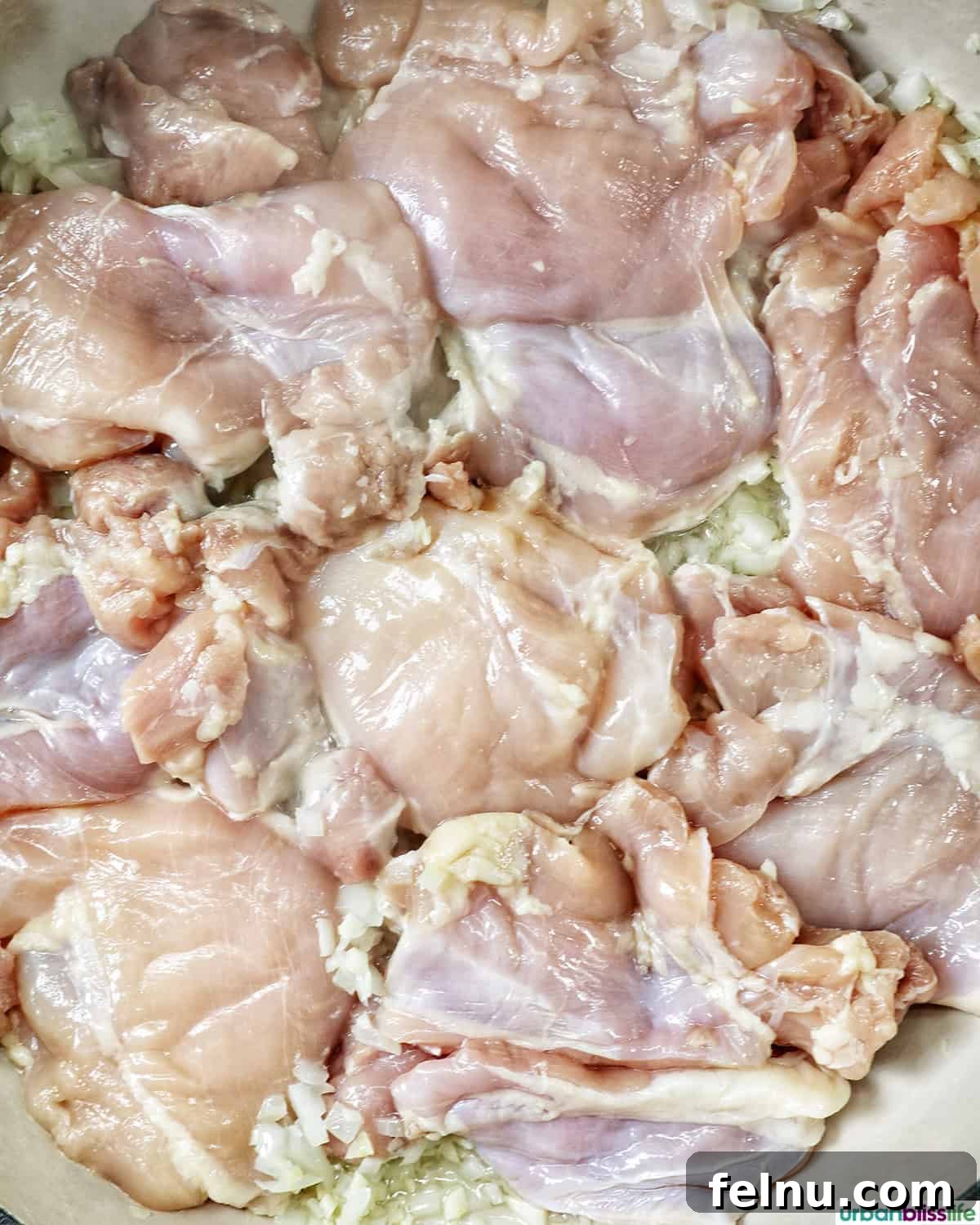 Rich Filipino Peanut Chicken 8 Pieces of chicken browning in a hot pan, acquiring a golden crust.