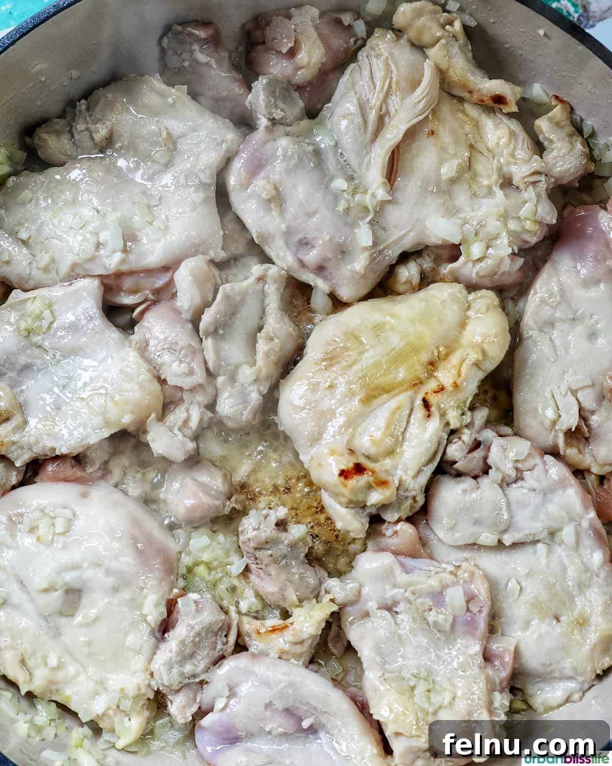 Rich Filipino Peanut Chicken 9 More chicken pieces cooking in a pan, developing a rich color.
