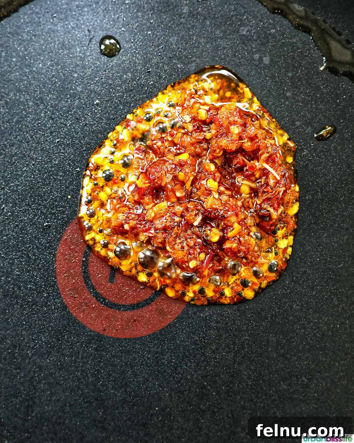 Golden Yolks, Fiery Crunch 6 Chili crisp and sesame oil heating in a non-stick pan, swirling together.
