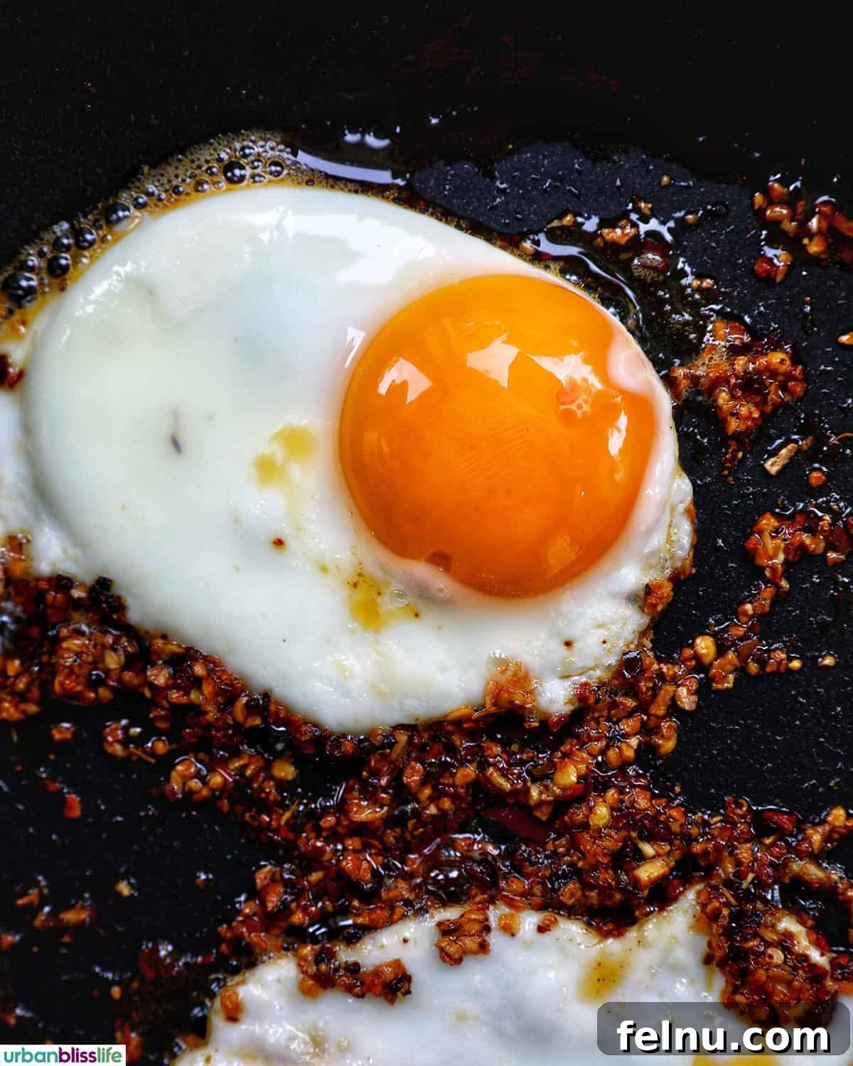 Golden Yolks, Fiery Crunch 9 A close-up of a chili crisp egg cooking in a pan, surrounded by the aromatic chili oil.