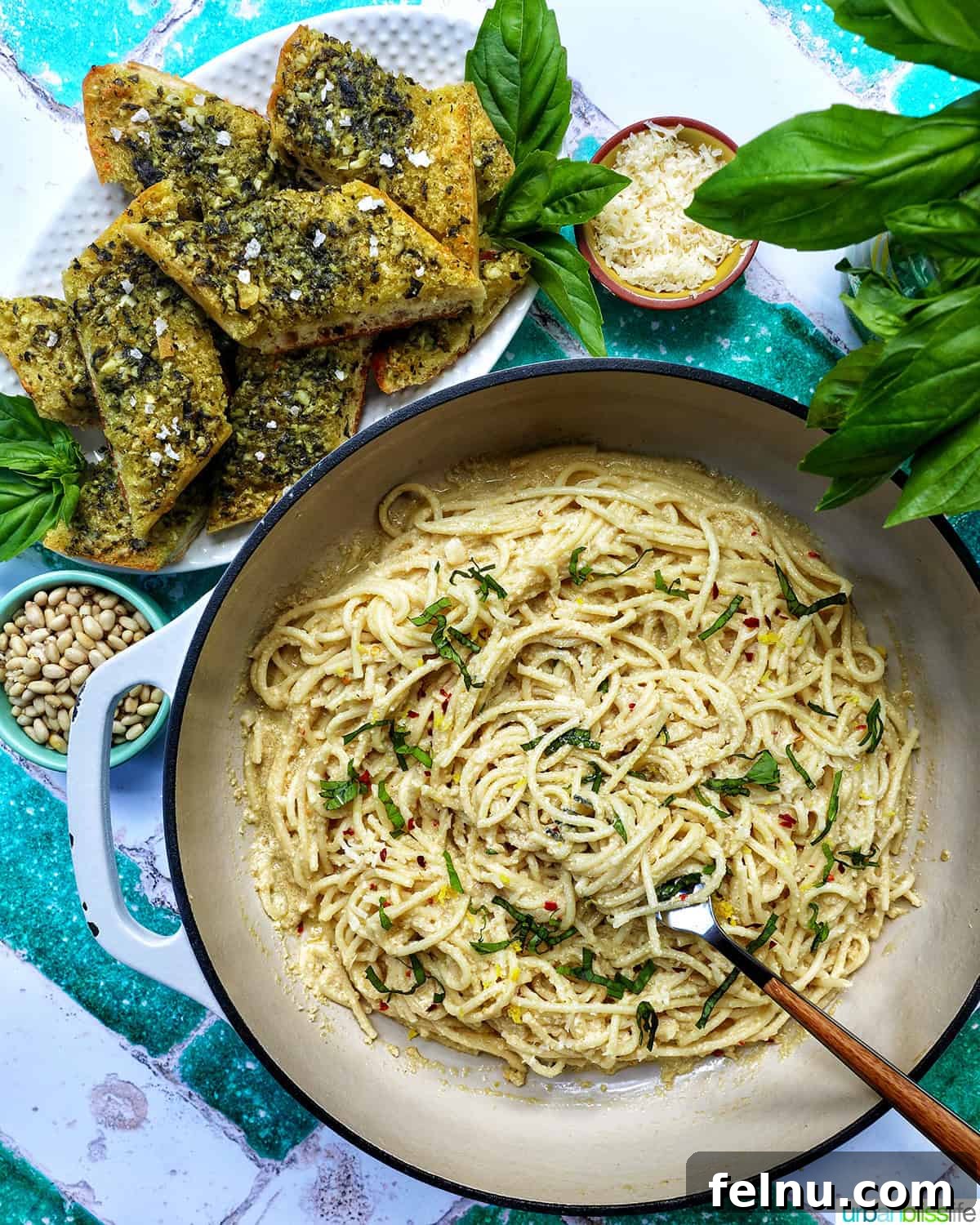 Cozy Fall Pasta Recipes 3 A saucepan of creamy tahini pasta, accompanied by pesto bread, pine nuts, cheese, and parsley.