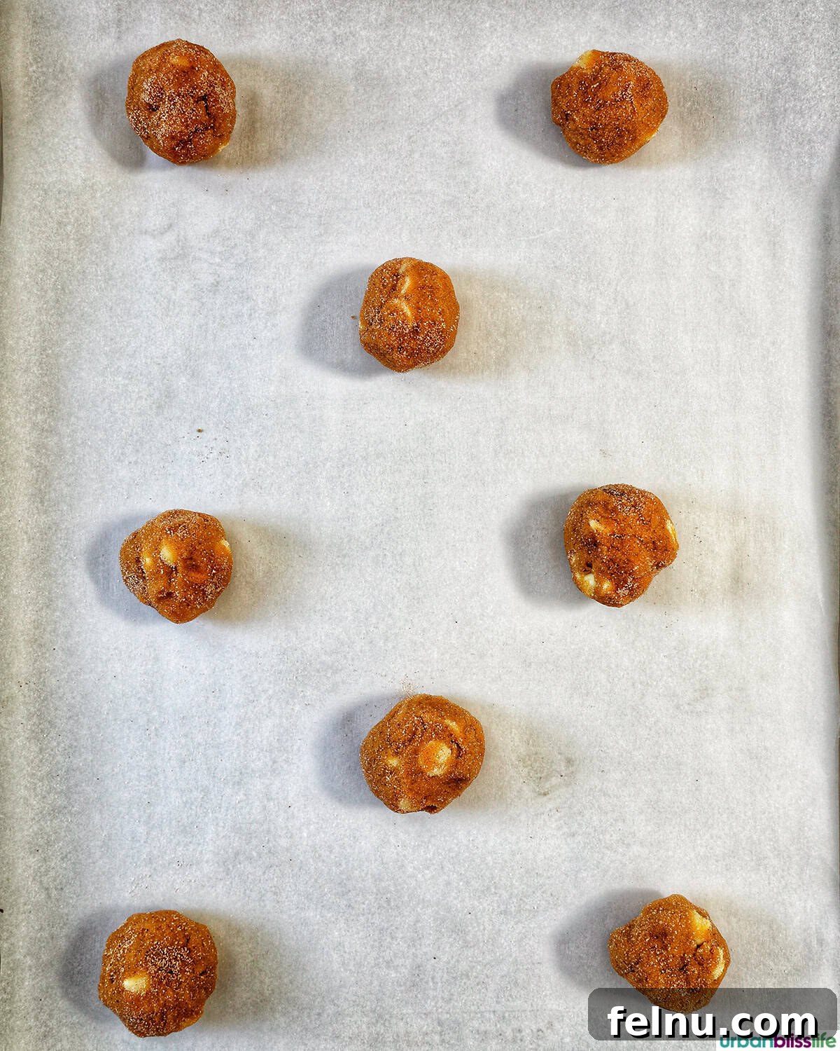 Pumpkin White Chocolate Chip Delights 15 Pumpkin white chocolate chip cookie balls on a baking sheet
