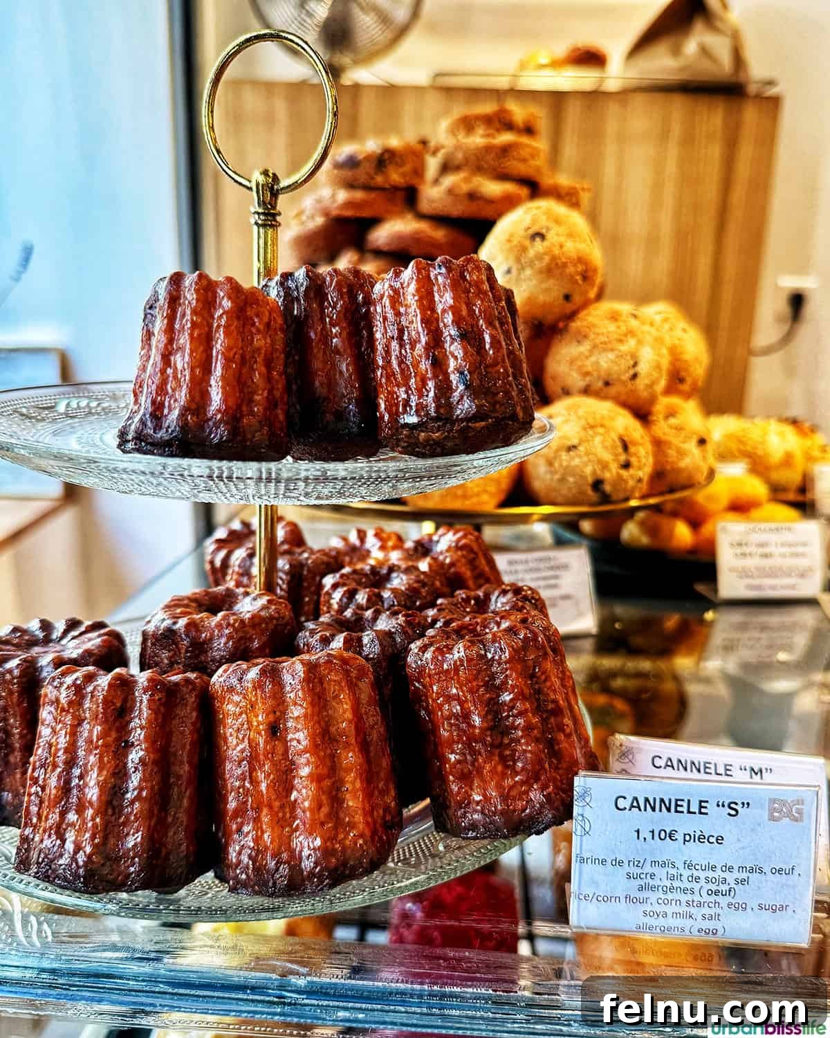 Bordeaux: A Baker's Dozen Expedition 15 A tiered display stand showcasing an abundance of perfectly baked Bordeaux cannelés, ready for eager customers to enjoy.