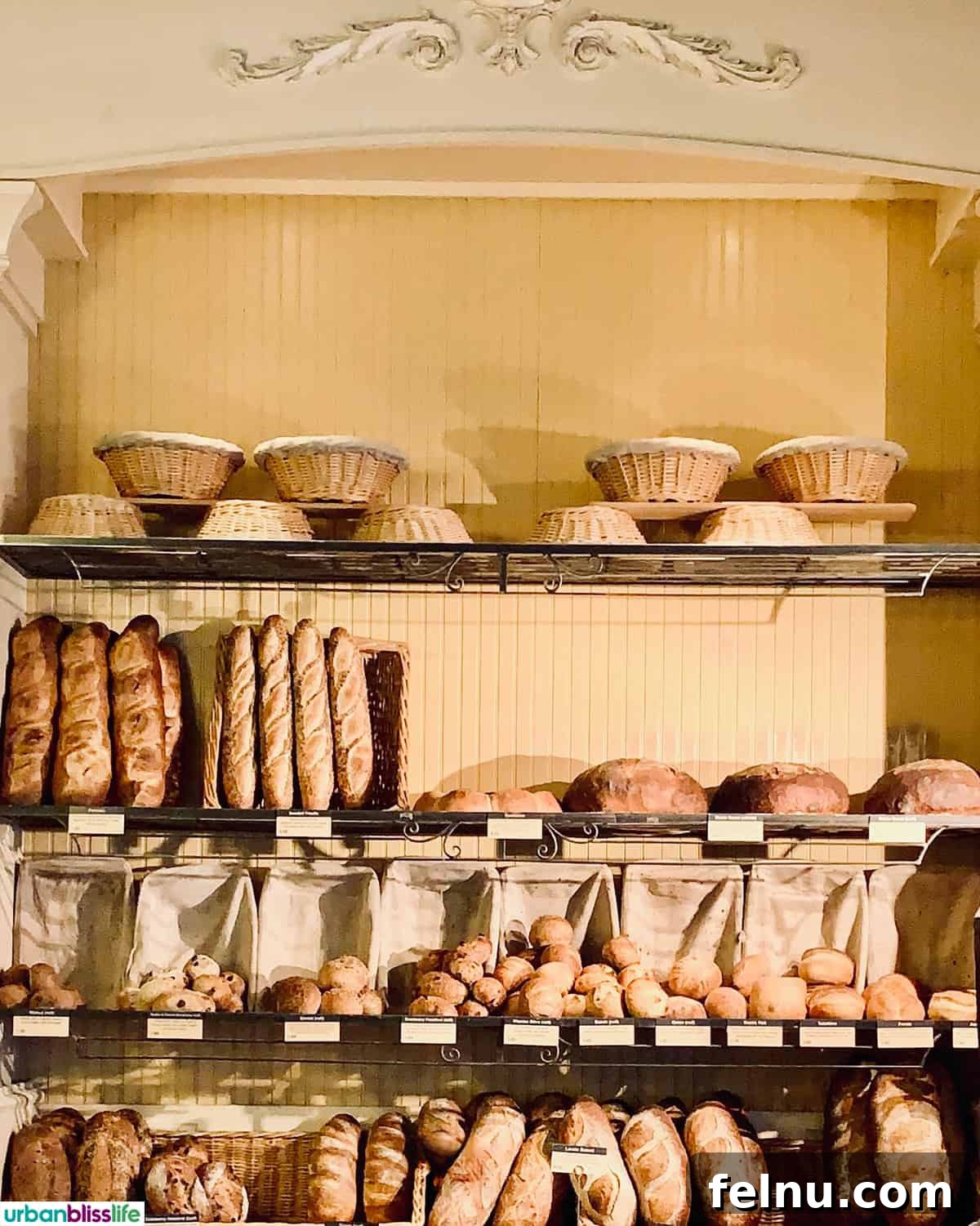 Bordeaux: A Baker's Dozen Expedition 3 An impressive display of various freshly baked bread loaves stacked against a wall inside a traditional French boulangerie, showcasing the artistry of the baker.