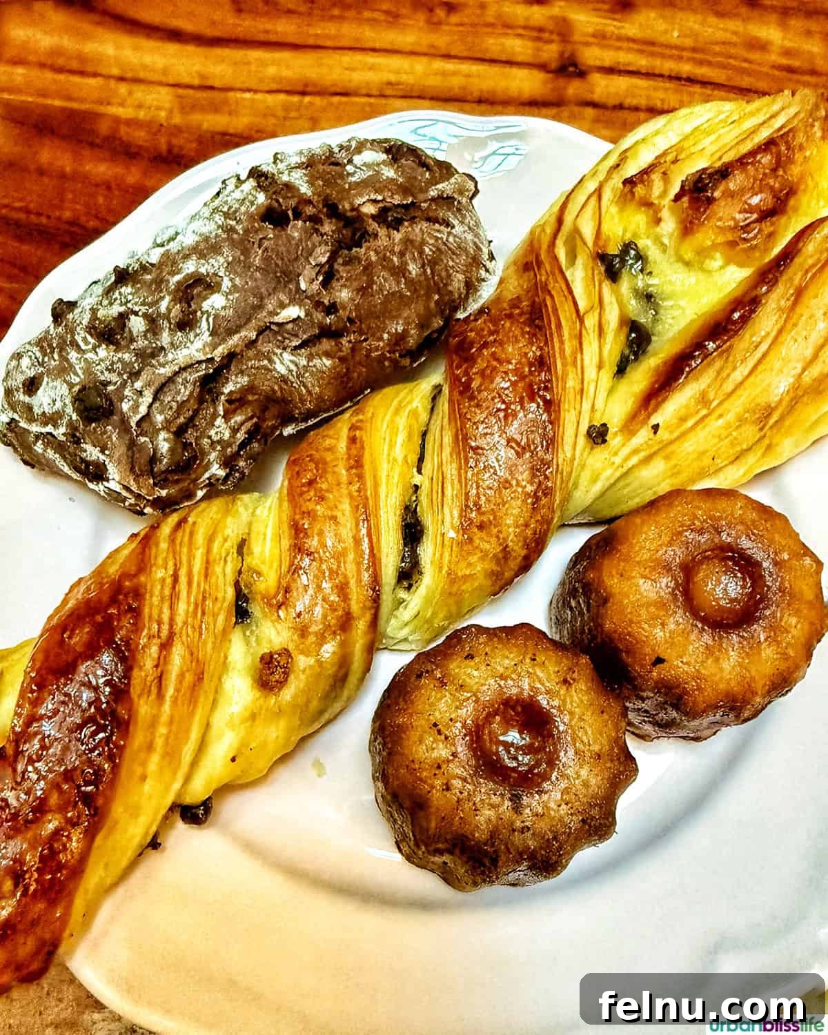 Bordeaux: A Baker's Dozen Expedition 4 A delightful array of colorful French pastries, including vibrant fruit tarts, éclairs, and canelés, beautifully arranged on a white plate, ready to be enjoyed.