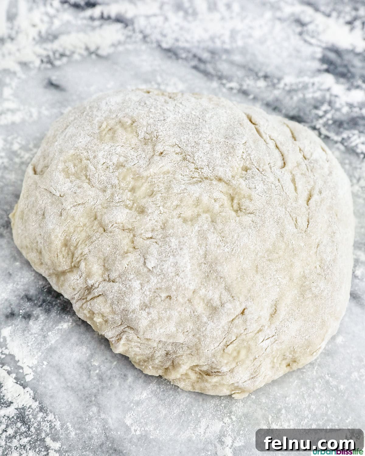 Kneading cinnamon roll dough on a lightly floured surface.