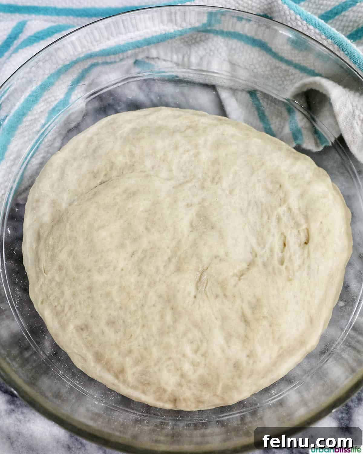 Fully risen cinnamon roll dough in a bowl, doubled in size.