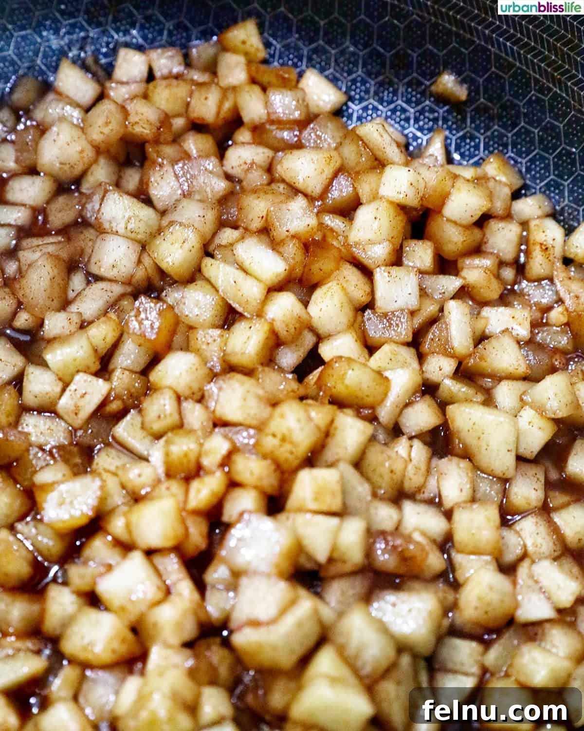Cooked, spiced diced apple pie filling in a pot, ready to be spread.