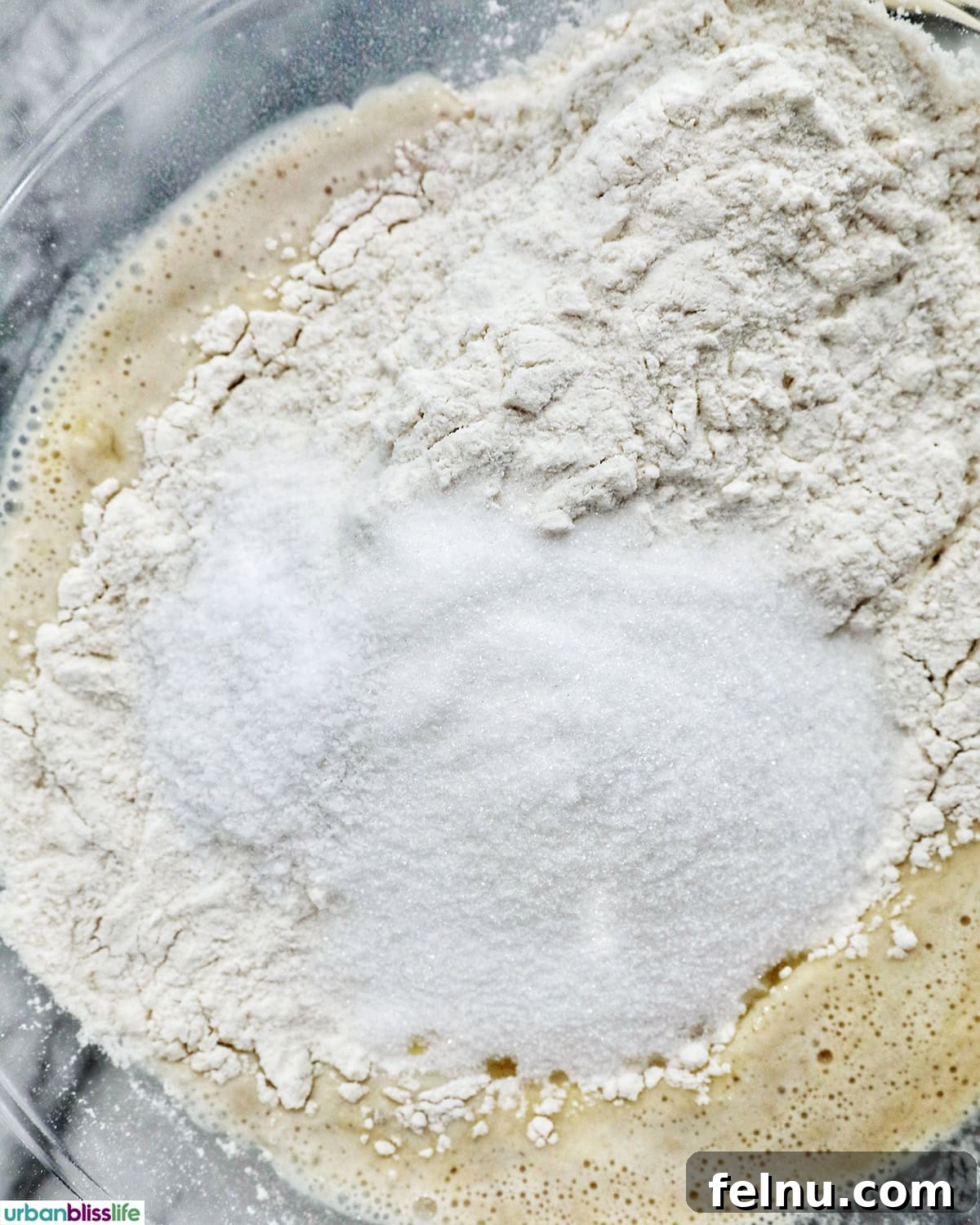 Mixing cinnamon roll batter in a bowl with a whisk.