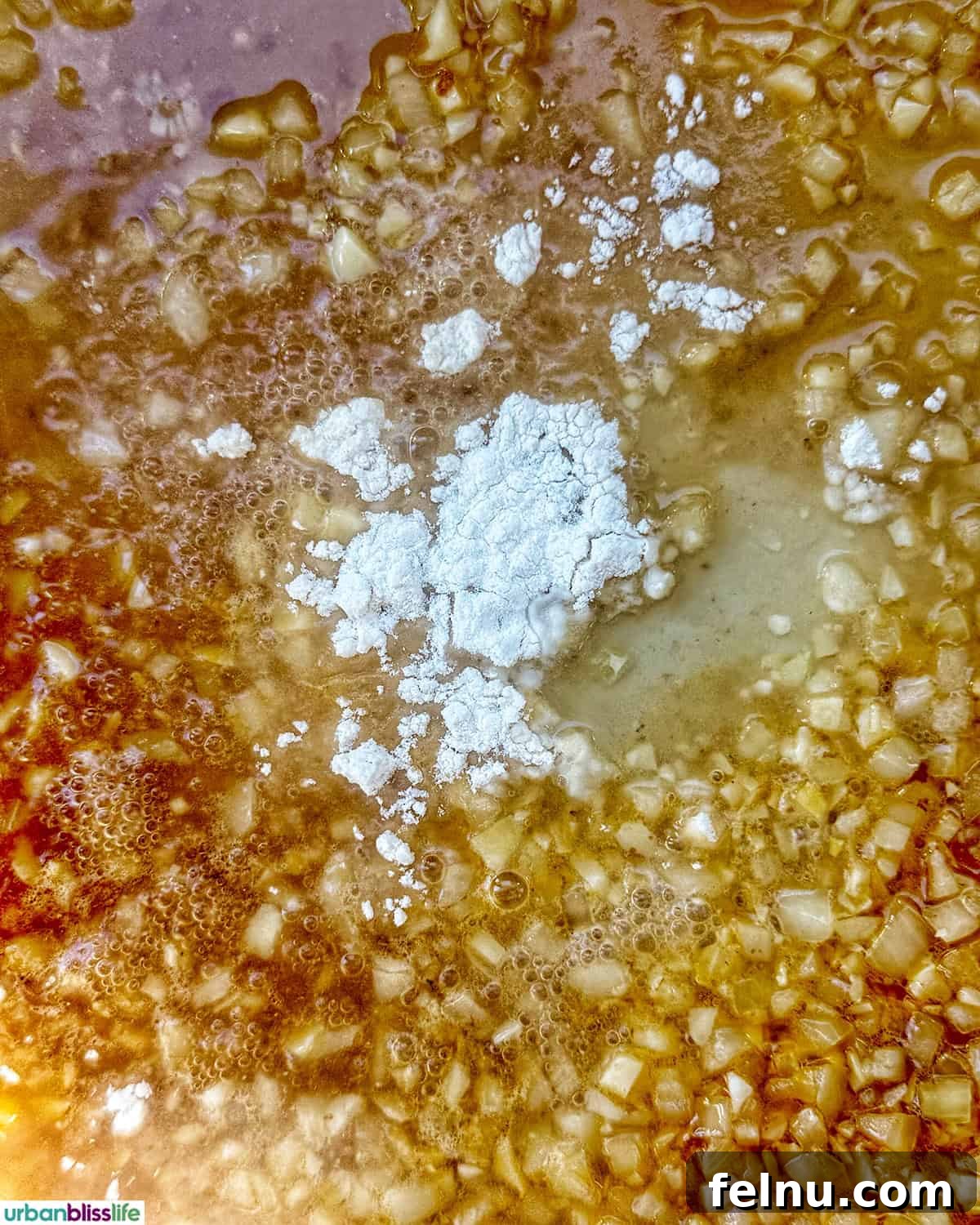 Tuscan Sausage Pasta Delight 11 Flour over garlic and shallots cooking in a pan