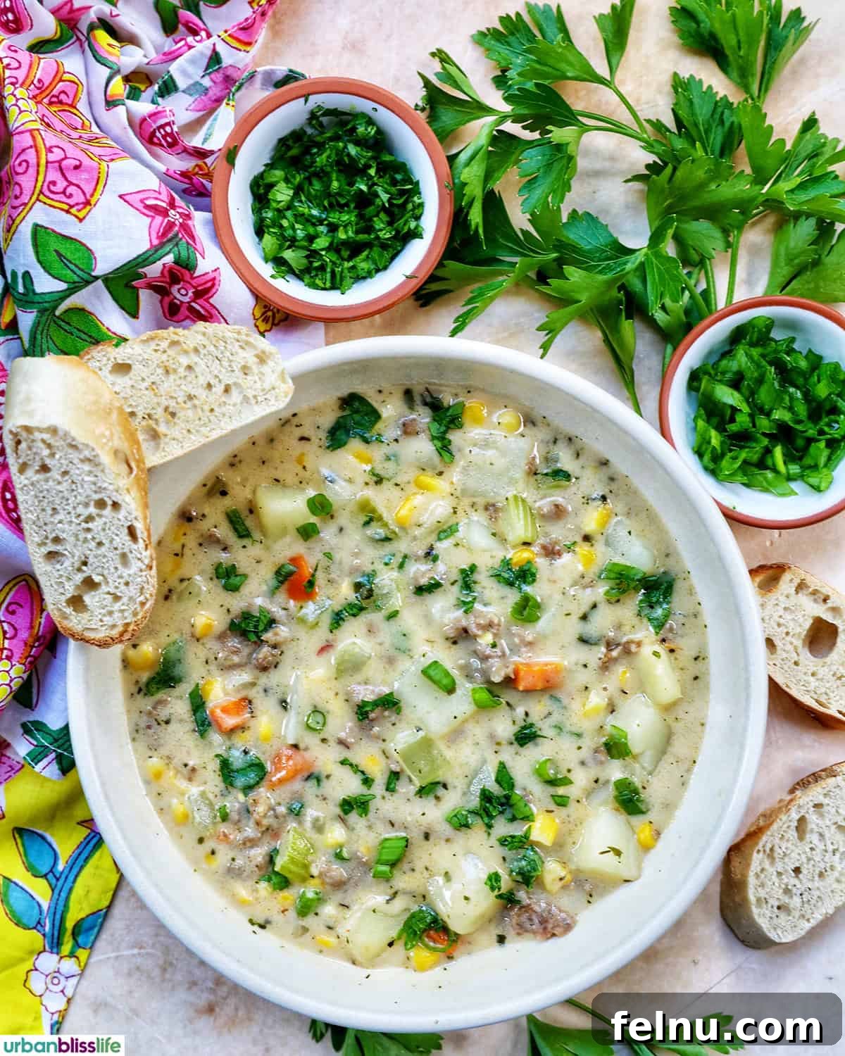 Smoky Sausage and Sweet Corn Chowder 16 A bowl of corn and sausage chowder garnished with fresh herbs, served alongside slices of crusty baguette.