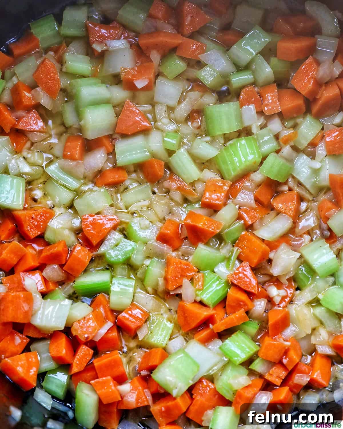 Smoky Sausage and Sweet Corn Chowder 9 Minced garlic added to sautéed carrots, celery, and onions in a pot.