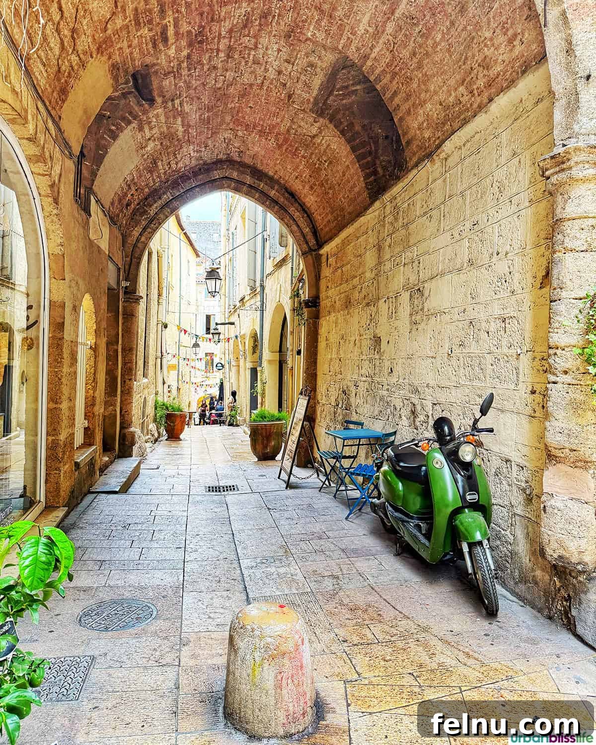 Montpellier Magic: Your Guide to a French Gem 36 A quaint alley in Montpellier, France, featuring a vibrant green Vespa, adding to the city's charm.