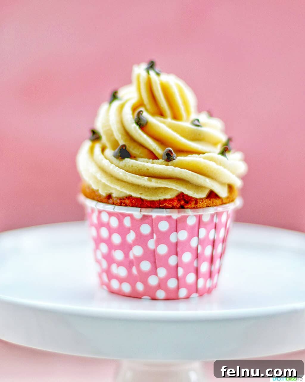 Chocolate Chip Cookie Dough Dream Cupcakes 13 One chocolate chip cupcake with cookie dough frosting in pink cup on white cake pedestal