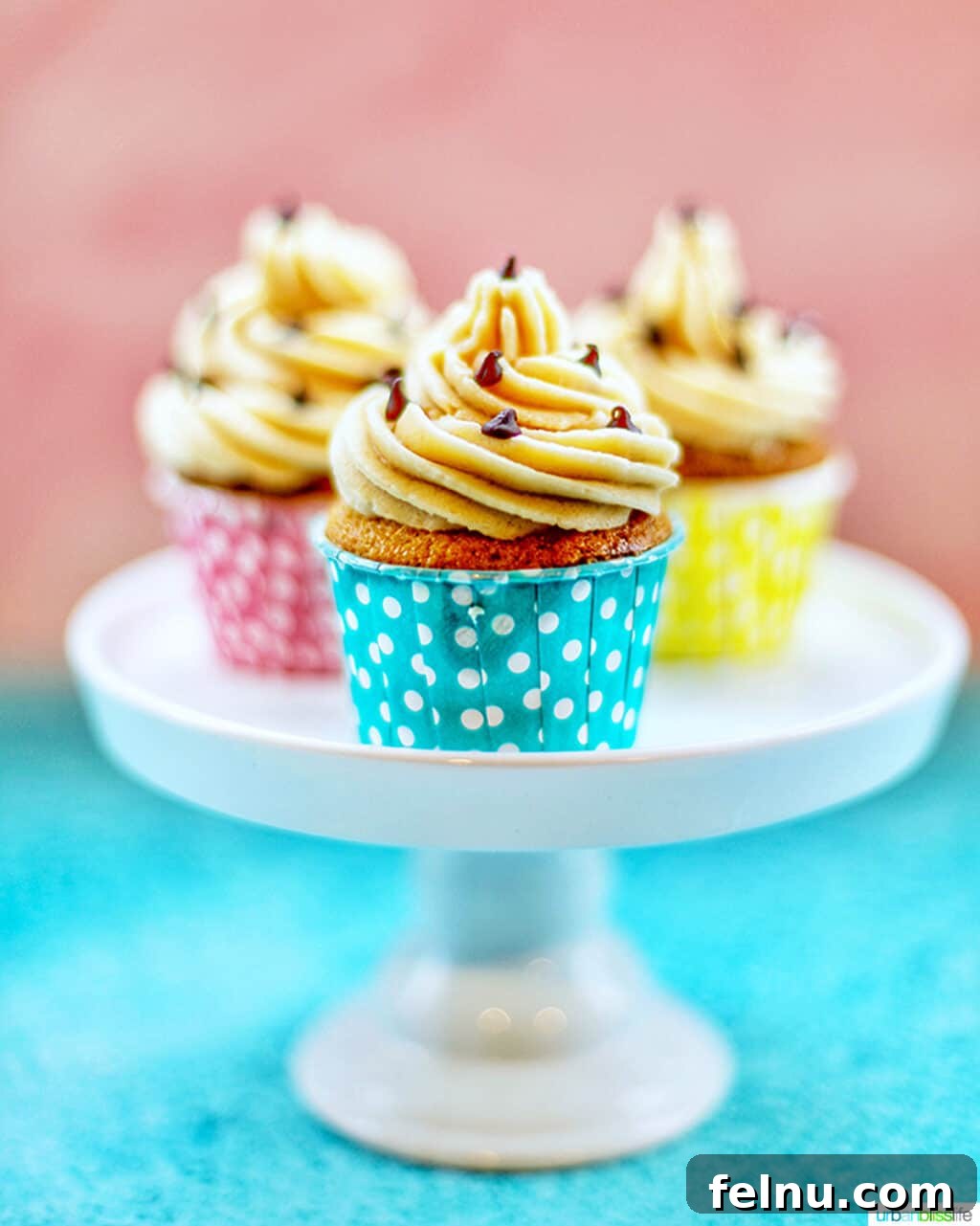 Chocolate Chip Cookie Dough Dream Cupcakes 5 Trio of chocolate chip cupcakes with cookie dough frosting in colorful polka dot baking cups on a white pedestal
