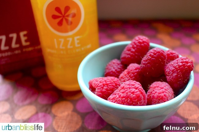 Clementine Love Sparkler 5 IZZE mixed drink recipe focusing on raspberries as a garnish.