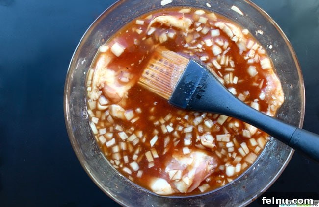 Ginger-Infused Grilled Chicken with Apple Cider Glaze 4 Cider Ginger Grilled Chicken Marinade being expertly applied with an OXO basting brush, ensuring maximum flavor infusion.
