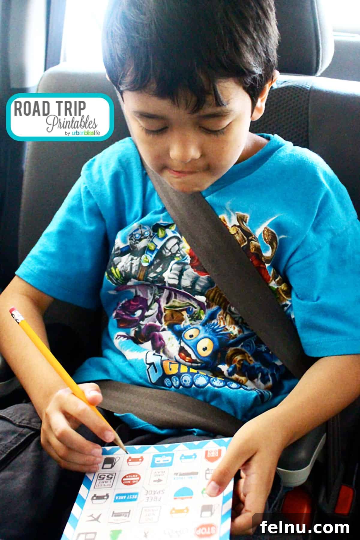 Fun Free Printable Games for Road Trips 3 A young boy, buckled in a car seat, enthusiastically marks his road trip bingo card with a pencil, fully engaged in the game.
