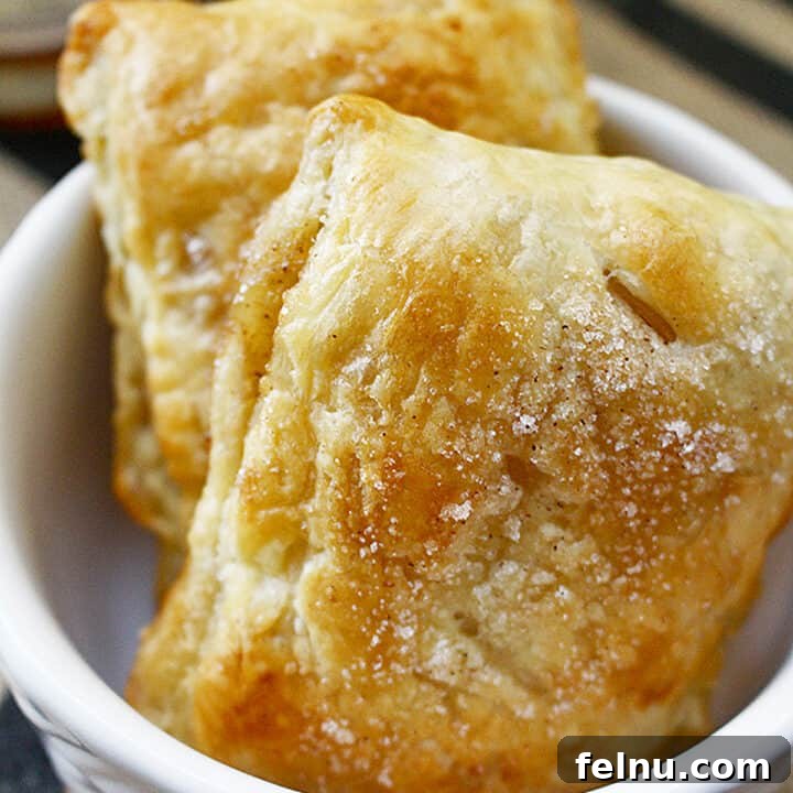 two apple whiskey hand pies in a white bowl.