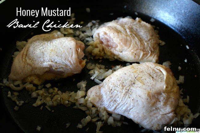 Glazed Honey Mustard Chicken Thighs with Bright Basil 3 Chicken thighs browning in a cast iron skillet with onions and garlic before adding sauce.