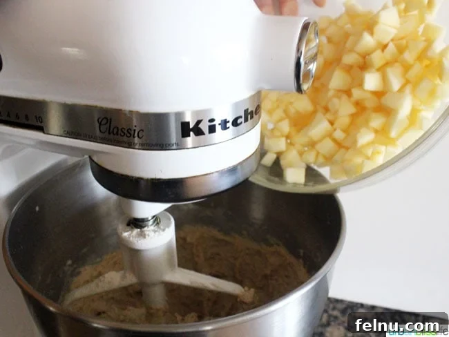 Mixing apples into batter for Apple Fritters, demonstrating the joy of creative baking in the kitchen