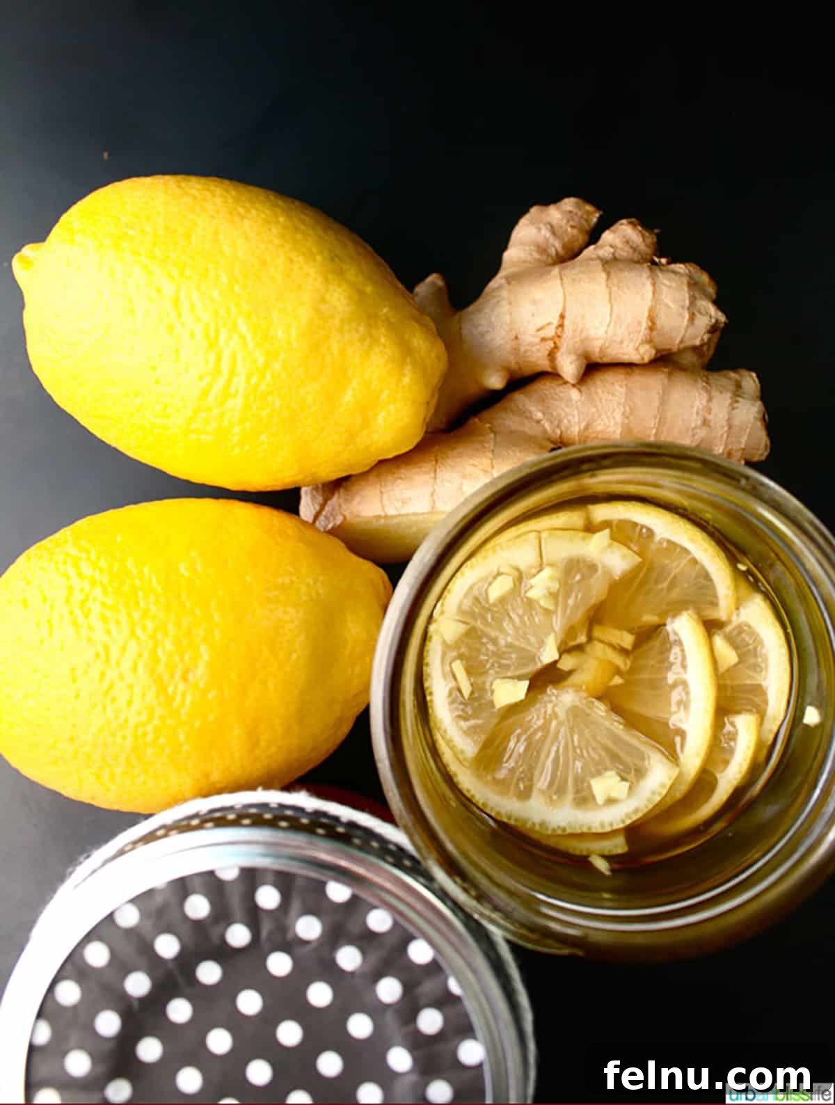 Lemon, ginger and honey syrup with two fresh lemons and fresh ginger