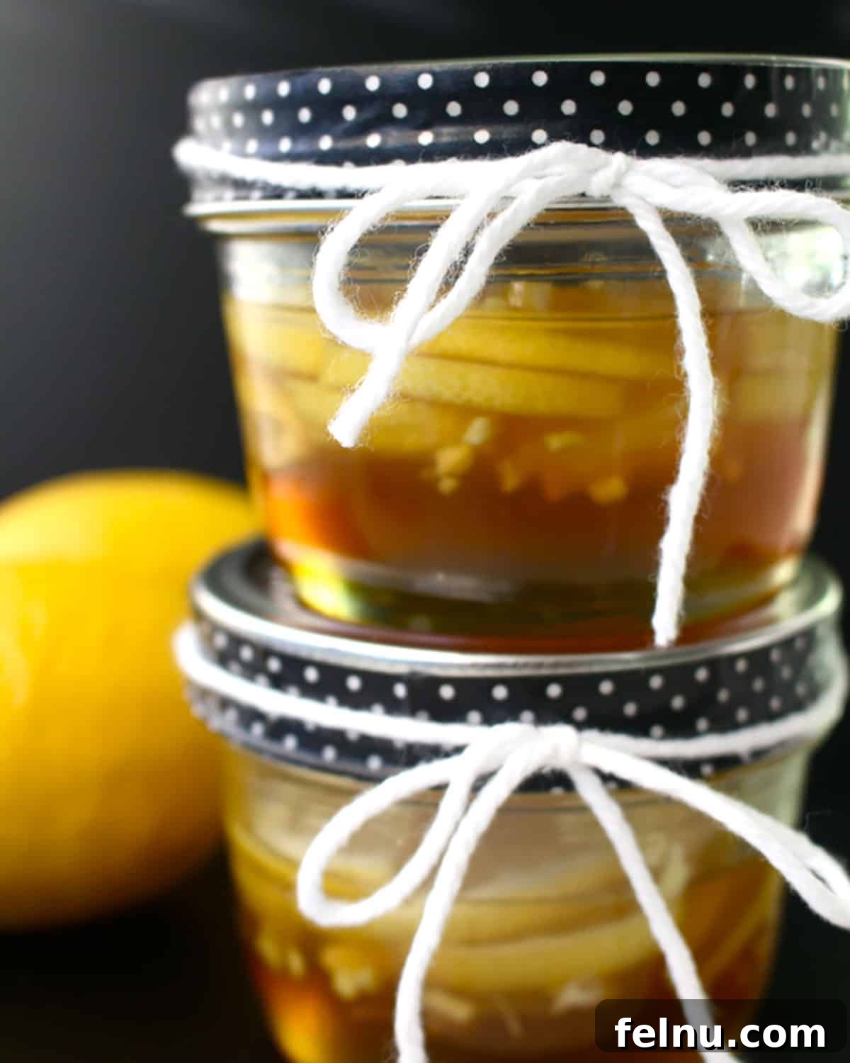 Ginger lemon honey syrup in two stacked mason jars