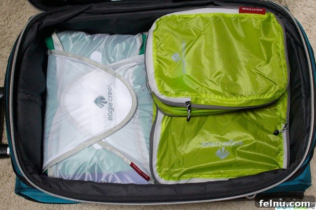 Effortless Packing for Extended Adventures 10 Extended stay travel essentials: a suitcase showing various packing organizers efficiently storing clothes.