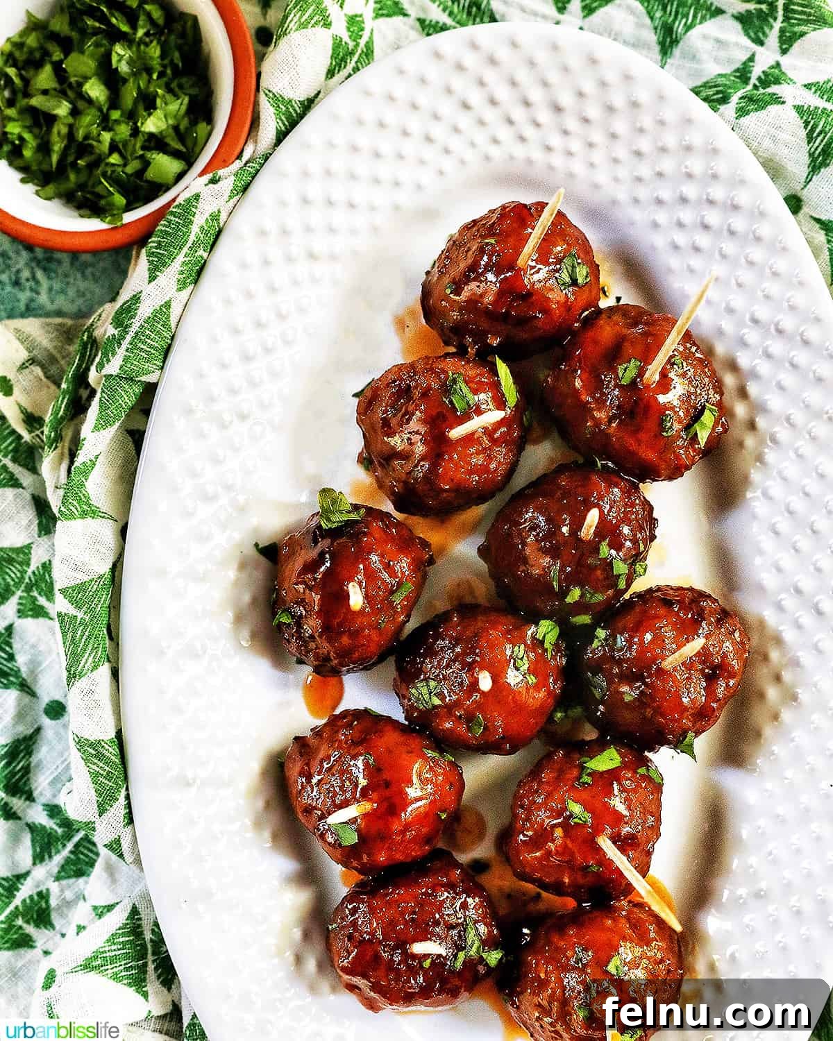 Honey Bourbon Glazed Meatballs (Slow Cooker Recipe) 14 Honey bourbon meatball appetizers on a platter with parsley.